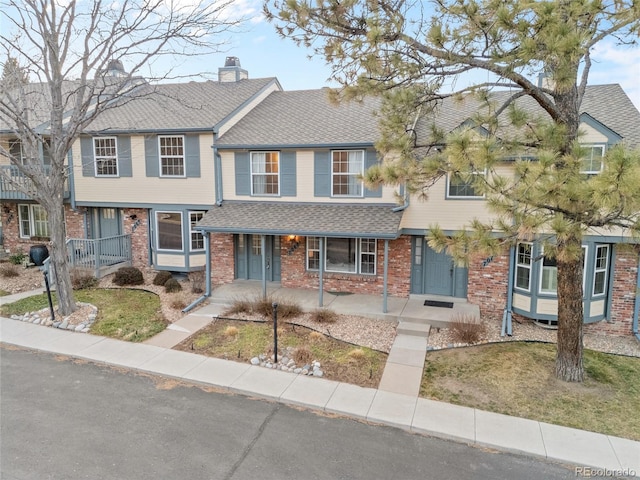 7068 E Briarwood Dr, Centennial, CO 80112 - multi unit property featuring brick siding, covered porch, a shingled roof, and a chimney