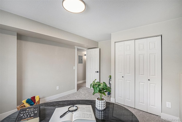 interior space featuring carpet flooring, a textured ceiling, and baseboards