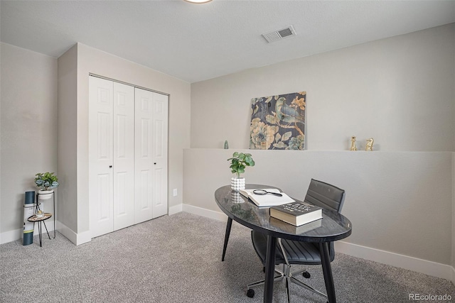 carpeted office with visible vents and baseboards