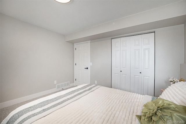 bedroom with carpet, a closet, visible vents, and baseboards