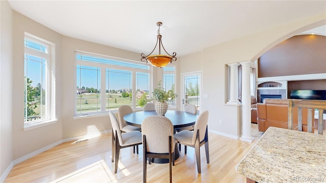 9353 E 146th Ave, Brighton, CO 80602 - dining space with light wood-type flooring, ornate columns, and arched walkways