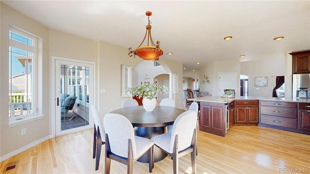 9353 E 146th Ave, Brighton, CO 80602 - dining room featuring ornate columns, light wood-type flooring, arched walkways, and recessed lighting