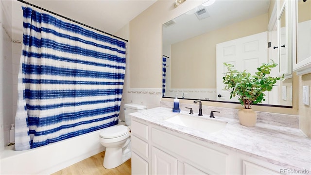 9353 E 146th Ave, Brighton, CO 80602 - full bathroom with vanity, shower / tub combo with curtain, tile walls, wood finished floors, and a wainscoted wall
