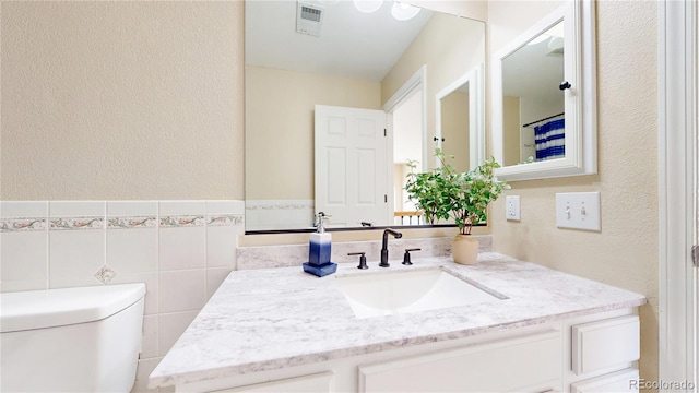 9353 E 146th Ave, Brighton, CO 80602 - bathroom featuring vanity, a textured wall, and tile walls