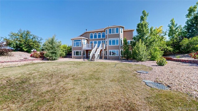 9353 E 146th Ave, Brighton, CO 80602 - back of property with stairway, a lawn, and a wooden deck