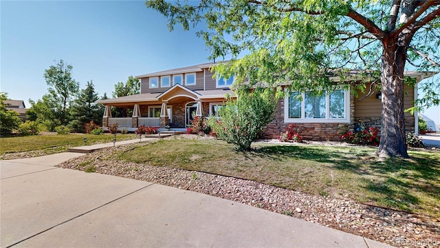 9353 E 146th Ave, Brighton, CO 80602 - view of front of home featuring covered porch, stone siding, and a front yard