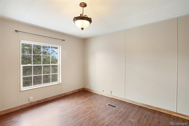empty room featuring wood finished floors and baseboards