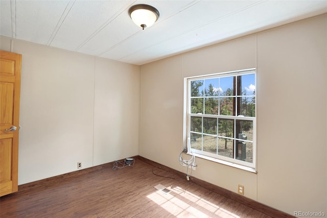 spare room with wood finished floors and baseboards