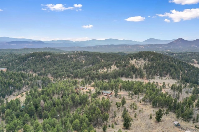 view of mountain backdrop featuring a heavily wooded area