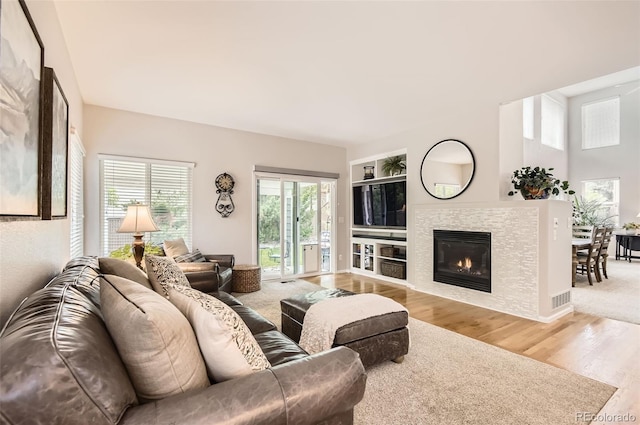 10230 Lauren Ct, Highlands Ranch, CO 80130 - living area featuring wood finished floors, a tiled fireplace, and built in shelves