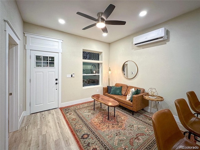 interior space with recessed lighting, a ceiling fan, baseboards, light wood finished floors, and a wall mounted air conditioner