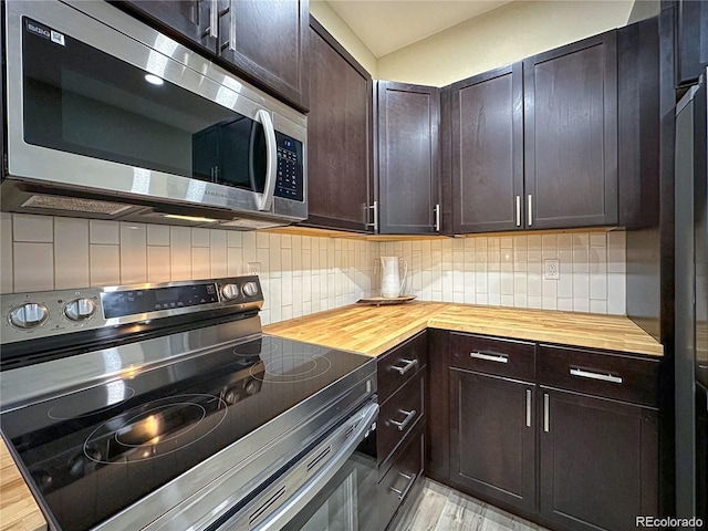 kitchen featuring butcher block counters, appliances with stainless steel finishes, decorative backsplash, and dark brown cabinets