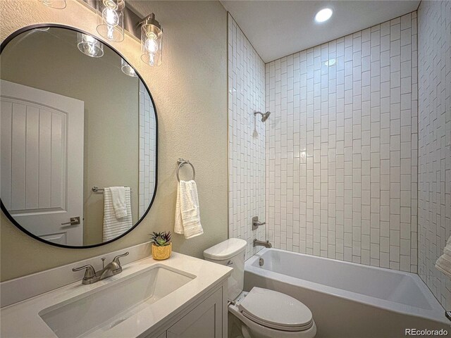 bathroom featuring a textured wall, bathtub / shower combination, toilet, recessed lighting, and vanity