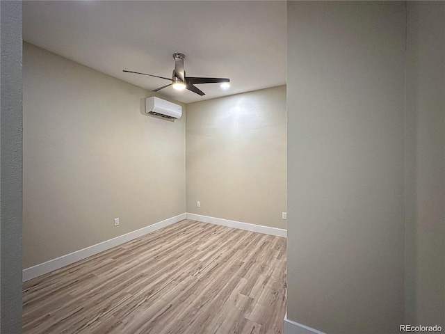 spare room featuring baseboards, a ceiling fan, wood finished floors, and a wall mounted AC