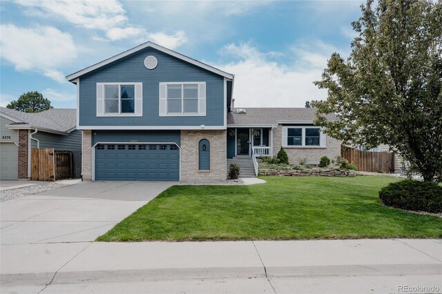 6386 S Pierson St, Littleton, CO 80127 - split level home featuring an attached garage, brick siding, and driveway