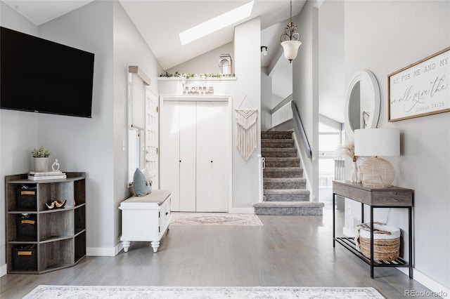 6386 S Pierson St, Littleton, CO 80127 - entryway featuring vaulted ceiling, a skylight, stairs, wood finished floors, and baseboards