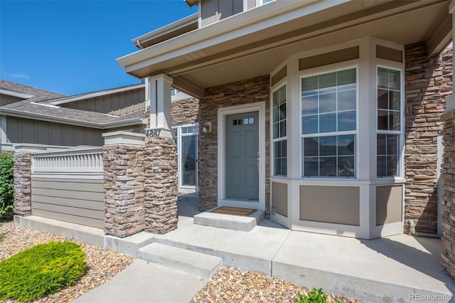 4887 Raven Run, Broomfield, CO 80023 - view of exterior entry featuring stone siding, board and batten siding, and covered porch