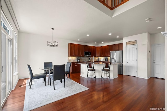 4887 Raven Run, Broomfield, CO 80023 - dining room featuring dark wood finished floors, recessed lighting, a chandelier, and baseboards