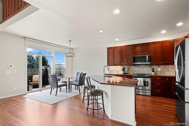 4887 Raven Run, Broomfield, CO 80023 - kitchen featuring stainless steel appliances, a sink, dark wood-style floors, tasteful backsplash, and recessed lighting