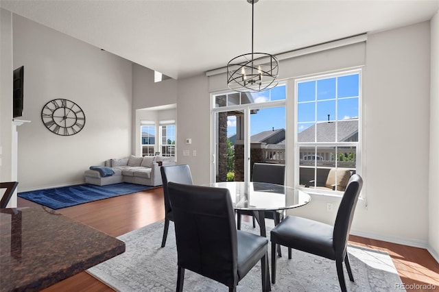 4887 Raven Run, Broomfield, CO 80023 - dining room featuring a chandelier, wood finished floors, and baseboards