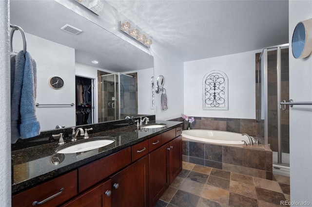 4887 Raven Run, Broomfield, CO 80023 - bathroom featuring a stall shower, a bath, double vanity, a walk in closet, and a textured ceiling