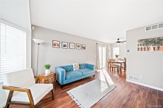 living room featuring ceiling fan and dark hardwood / wood-style floors