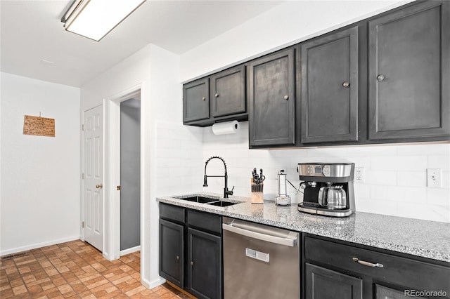 kitchen featuring tasteful backsplash, stainless steel dishwasher, light stone countertops, and sink