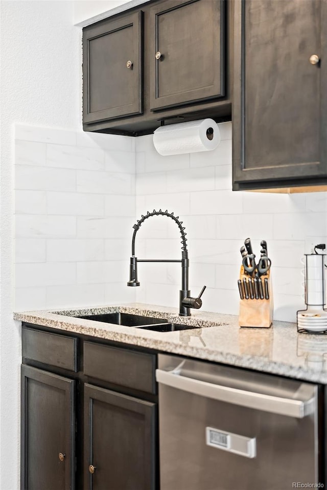 kitchen featuring dishwasher, light stone countertops, and dark brown cabinetry