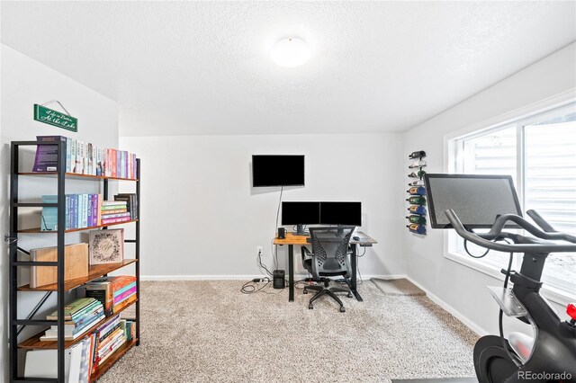 carpeted office featuring a textured ceiling