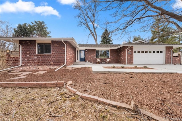 ranch-style home with driveway, brick siding, and an attached garage