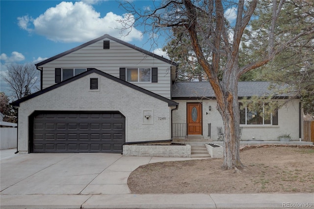 tri-level home with brick siding, driveway, a garage, and roof with shingles