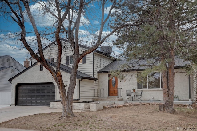 view of front of property featuring a garage, brick siding, and concrete driveway