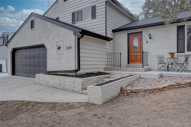 view of front of property with an attached garage, brick siding, and driveway