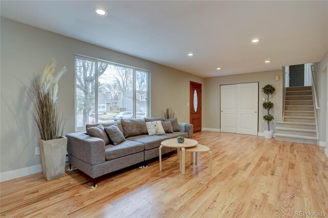 living area featuring recessed lighting, stairs, and light wood finished floors