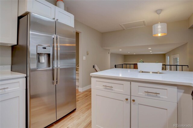 kitchen with light countertops, white cabinets, and stainless steel refrigerator with ice dispenser