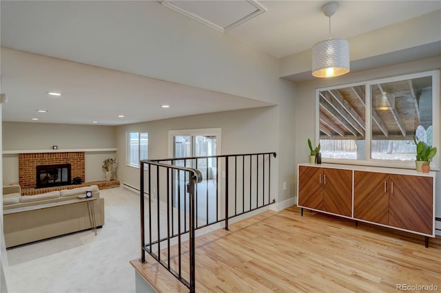 interior space with light wood finished floors, an upstairs landing, recessed lighting, and baseboards