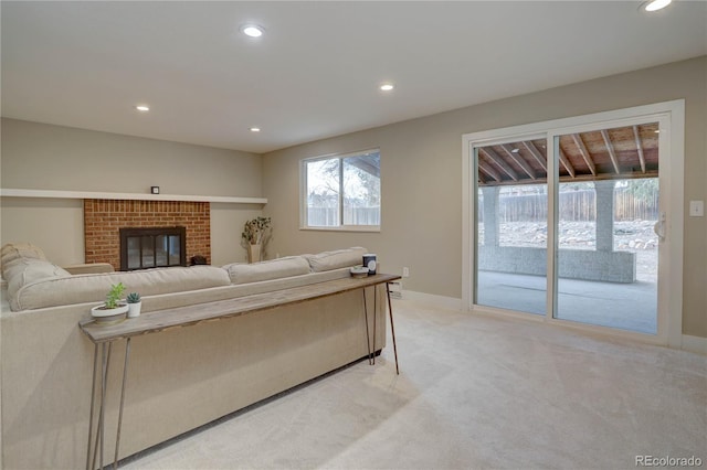 living area featuring light carpet, recessed lighting, a brick fireplace, and baseboards