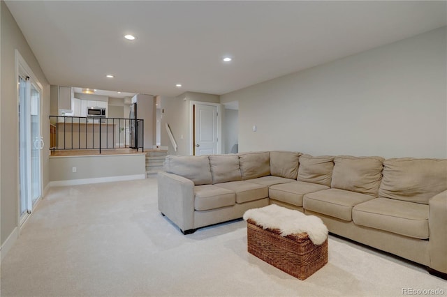 living area featuring stairway, recessed lighting, baseboards, and light carpet