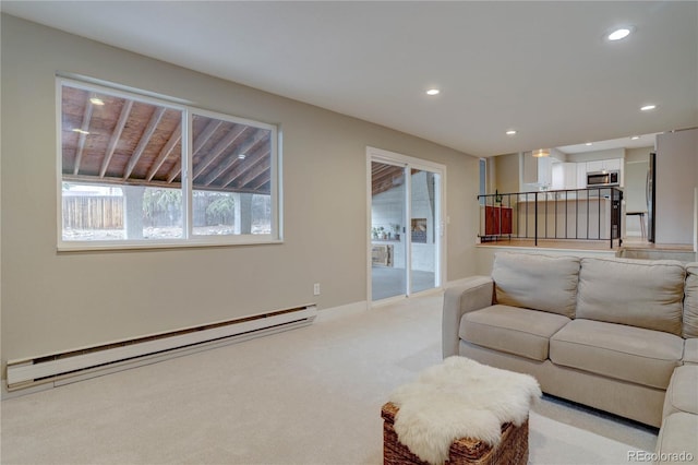 living area featuring recessed lighting, a baseboard heating unit, baseboards, and light colored carpet