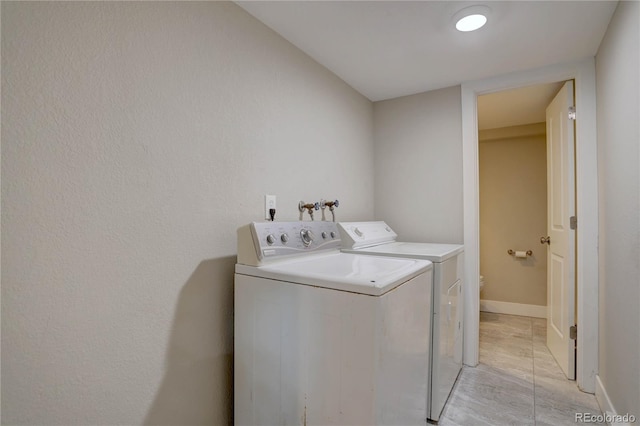 laundry area with laundry area, baseboards, and washer and clothes dryer