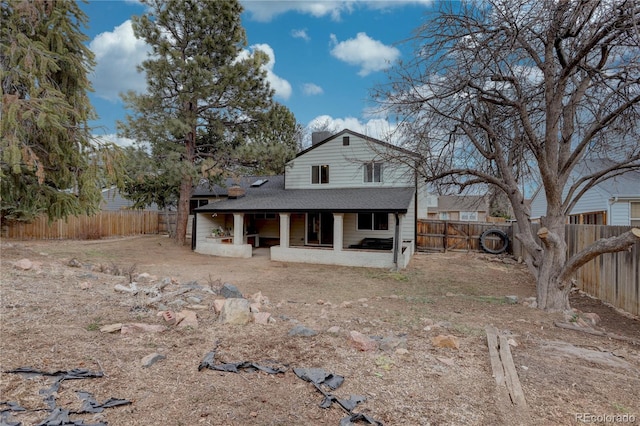 view of front of house with a patio, a fenced backyard, and a shingled roof