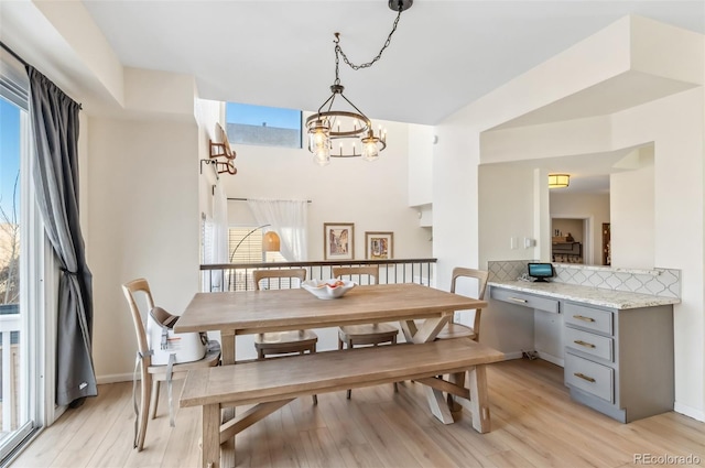 dining area featuring a notable chandelier and light wood-type flooring