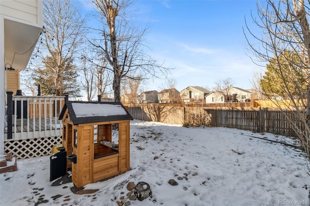 yard layered in snow with a wooden deck