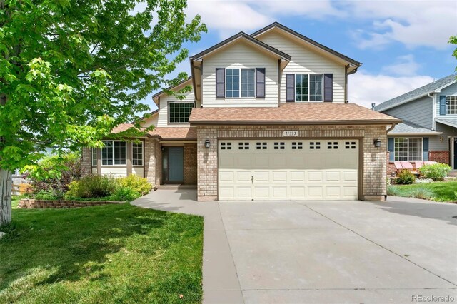 11335 W 54th Ln, Arvada, CO 80002 - traditional home with driveway, an attached garage, brick siding, and a front lawn