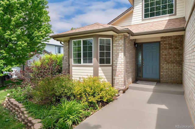 11335 W 54th Ln, Arvada, CO 80002 - view of exterior entry with brick siding and a shingled roof