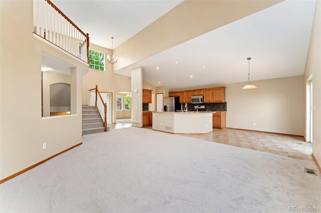 11335 W 54th Ln, Arvada, CO 80002 - unfurnished living room with baseboards, light carpet, stairway, a towering ceiling, and a sink