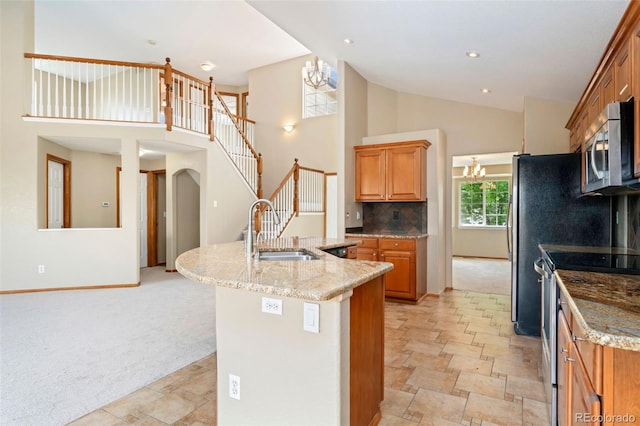 11335 W 54th Ln, Arvada, CO 80002 - kitchen with a sink, stainless steel appliances, stone finish flooring, light stone counters, and high vaulted ceiling