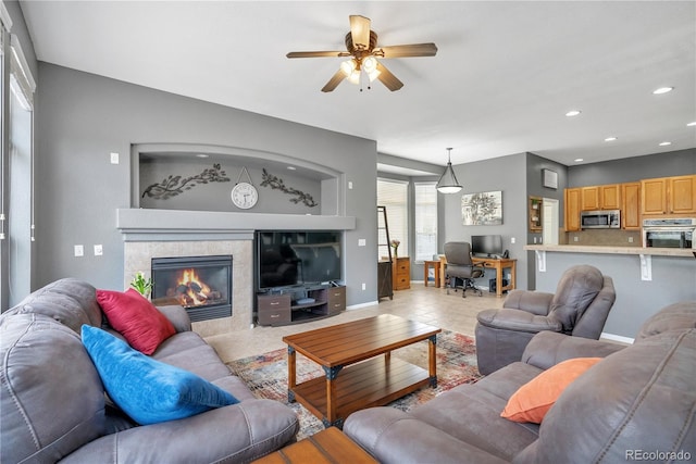 living area featuring a ceiling fan, light tile patterned floors, a fireplace, baseboards, and recessed lighting