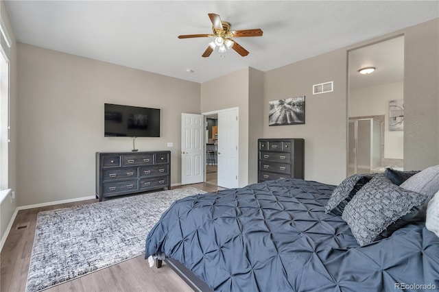 bedroom with ceiling fan, baseboards, wood finished floors, and visible vents