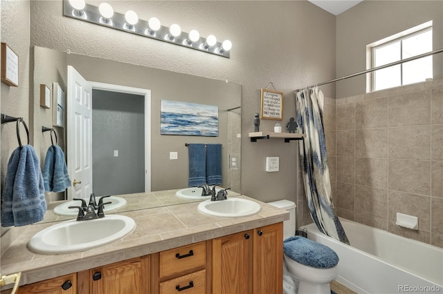 bathroom with toilet, shower / tub combo with curtain, a sink, and double vanity